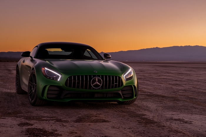 Green Mercedes-AMG GT R sports car in desert at sunset