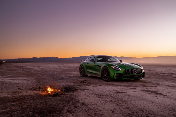 Green Mercedes-AMG GT R sports car on desert landscape at sunset