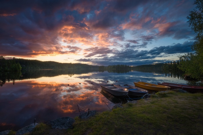 Boats on a lake at sunset with colorful clouds