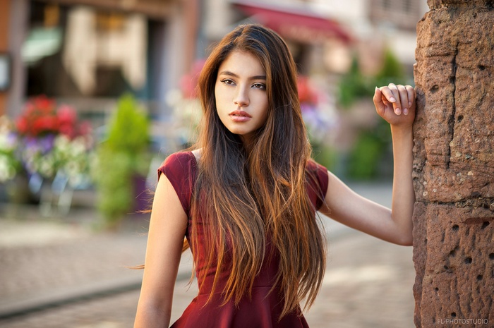 Woman with long brown hair in a red dress outdoors