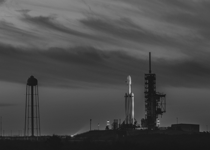 SpaceX Falcon Heavy rocket on launchpad at night