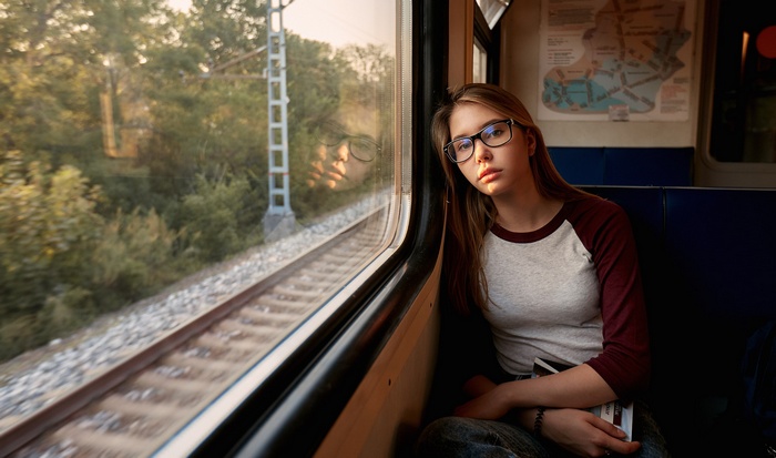 Young woman with glasses on a train