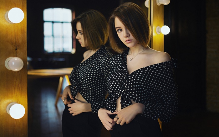 Woman in polka dot shirt reflected in a mirror