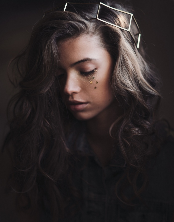 Woman with curly hair and star glitter on face