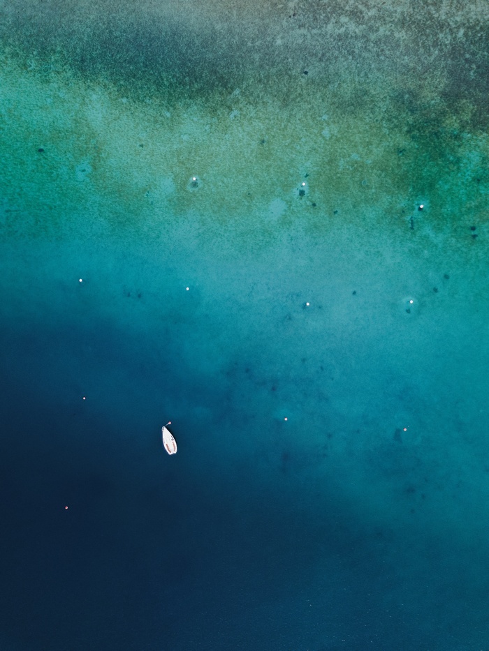 Aerial view of a white boat on turquoise water