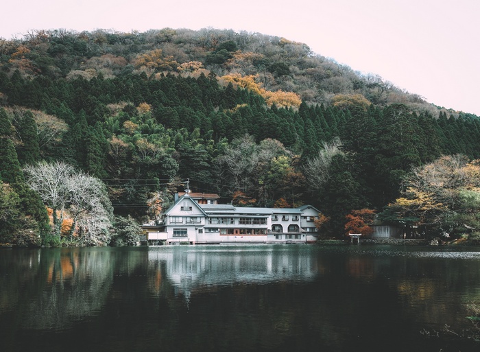 Building on a lake with a forested mountain background