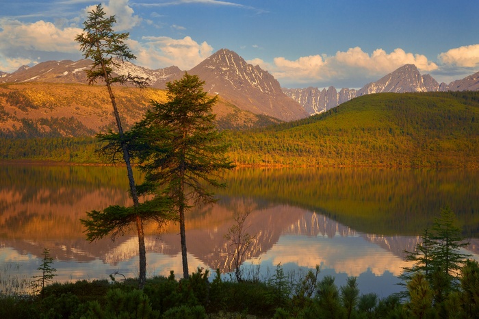 Lake reflection of mountains and trees at sunset