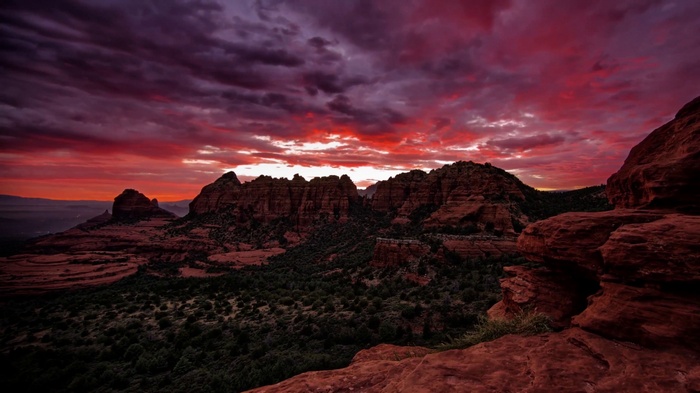Dramatic sunset over red rock formations and desert landscape