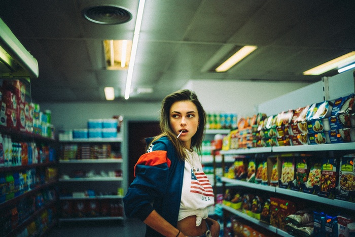 Woman with lollipop in a convenience store