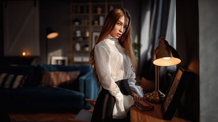 Woman with long hair in a white blouse and black skirt