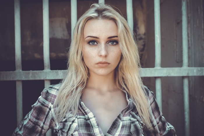 Woman with blonde hair and freckles wearing a plaid shirt