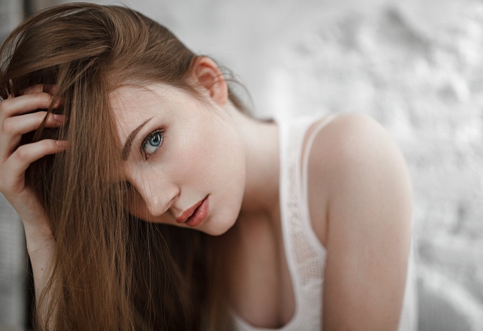 Woman with blue eyes and hand on head