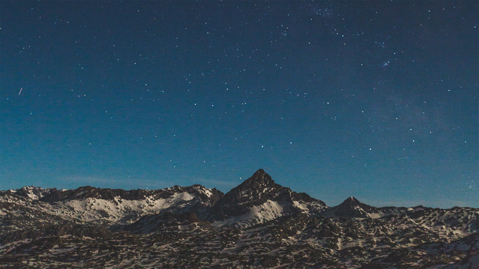 Snow-covered mountains under a starry night sky