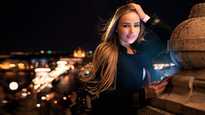 Woman with smartphone in Budapest at night