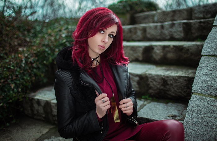 Woman with red hair sitting on stone stairs