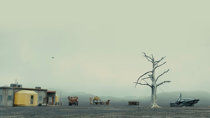 Blade Runner 2049 desolate landscape with vehicles and a dead tree