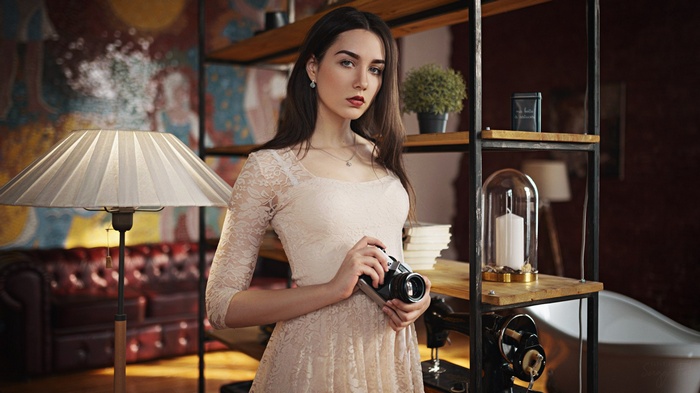 Woman holding a camera in a room