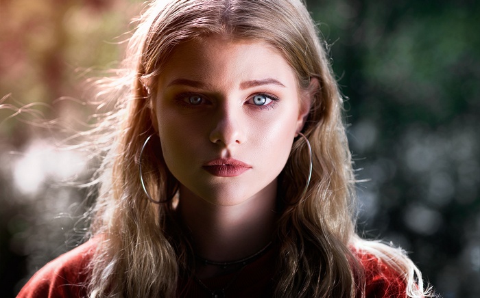 Portrait of a blonde woman with blue eyes and hoop earrings