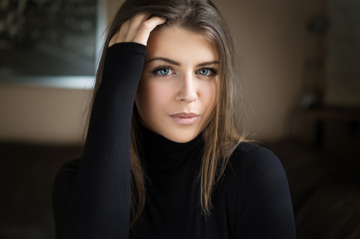 Woman with blue eyes and hand on head