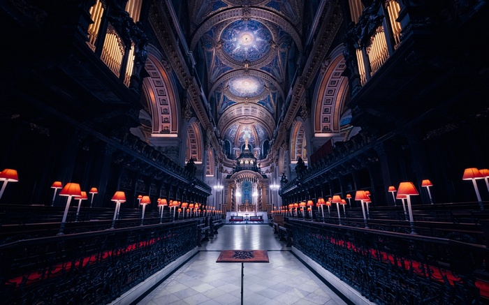 Interior of a grand cathedral with ornate ceiling and red lamps