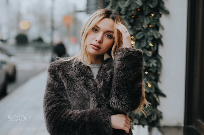 Woman with blonde hair wearing a fur coat outdoors