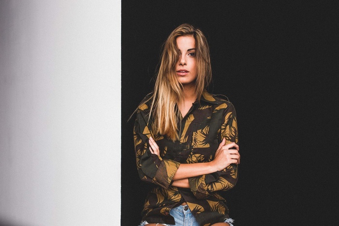 Woman in camouflage shirt and jean shorts