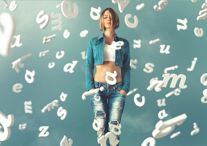 Woman in torn jeans surrounded by letters