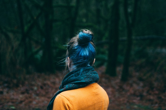 Woman with blue dyed hair in a forest