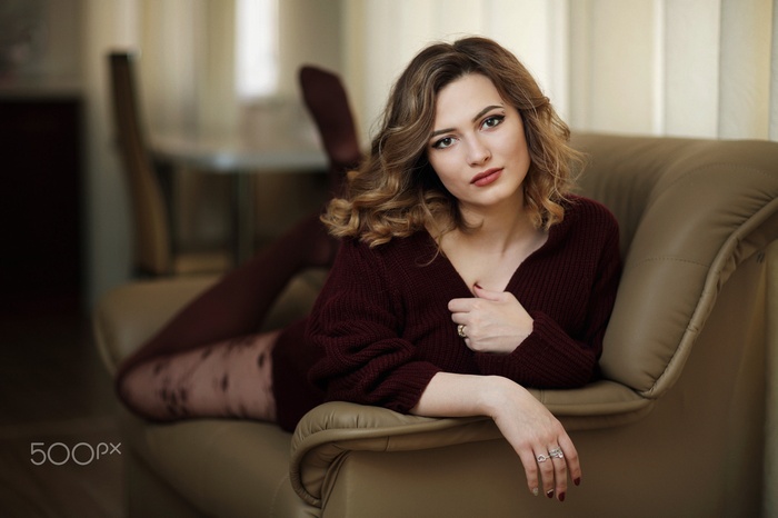 lying on front, pantyhose, couch, sweater, pierced eyebrow, depth of field, wide jaw, women, brown eyes, Murat Kuzhakhmetov, face, brunette, wavy hair