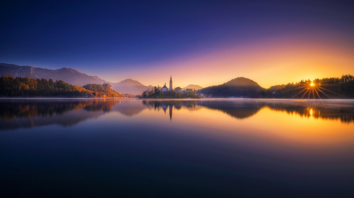 Sunrise over Lake Bled with island church and mountains