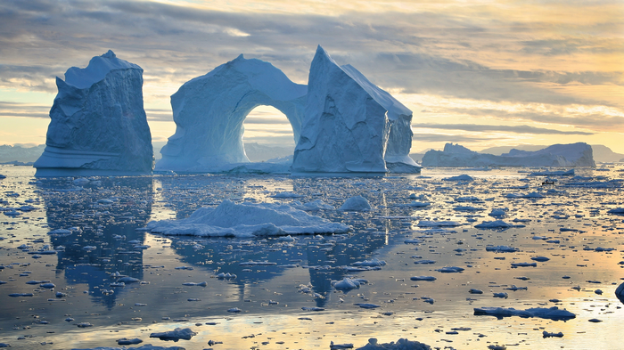Icebergs floating in the ocean at sunset