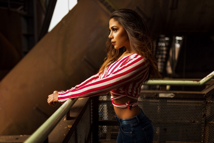 Woman in striped top and jeans looking away