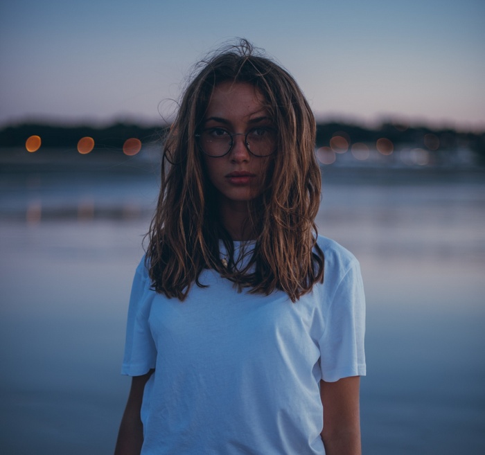 Woman wearing glasses and white t-shirt outdoors