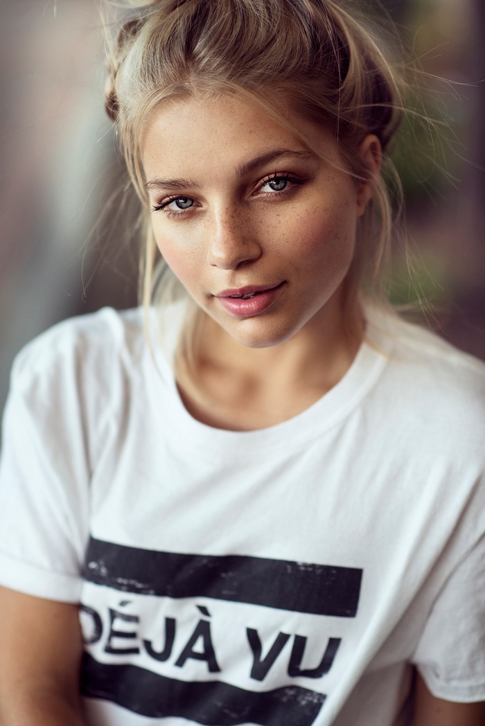 Woman with blonde hair and freckles wearing a white t-shirt