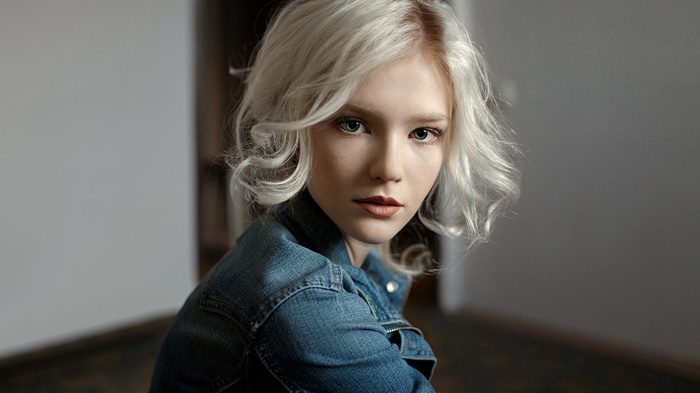 Woman with blonde hair and blue eyes in denim jacket