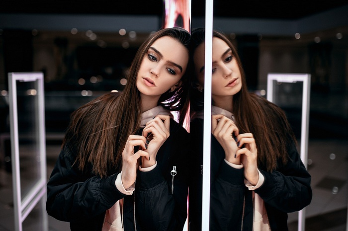 Woman leaning against a reflective surface