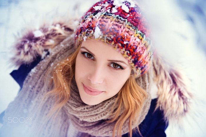 Woman in colorful hat and scarf in snow