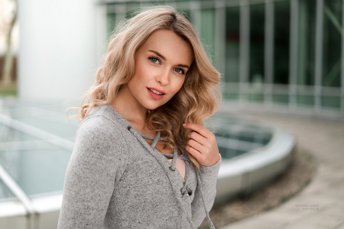 Woman with blonde wavy hair looking at viewer