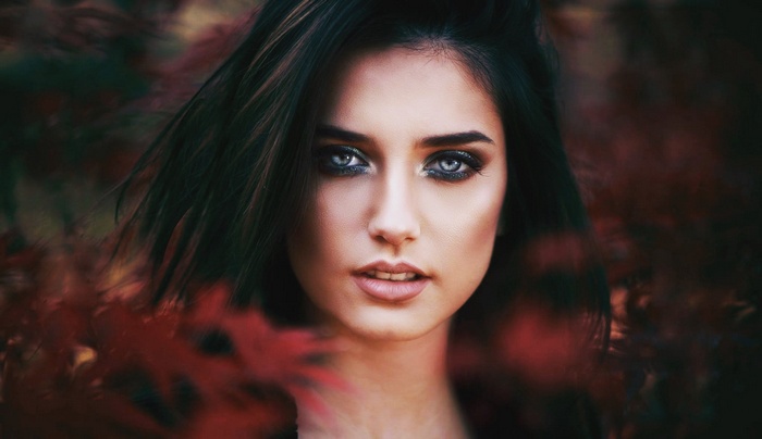 Woman with smoky eyes and dark hair outdoors