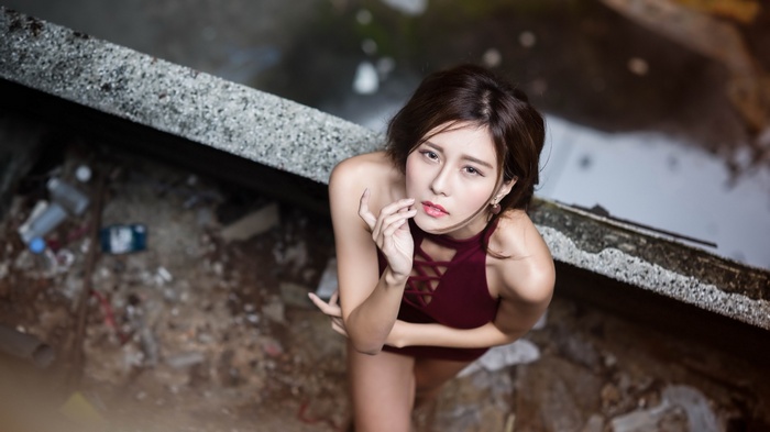 Asian woman in a maroon swimsuit posing
