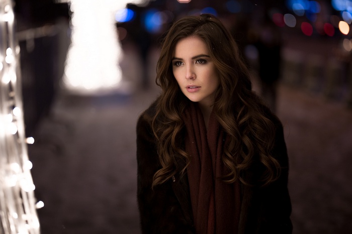 Woman with long brown hair wearing a fur coat and scarf