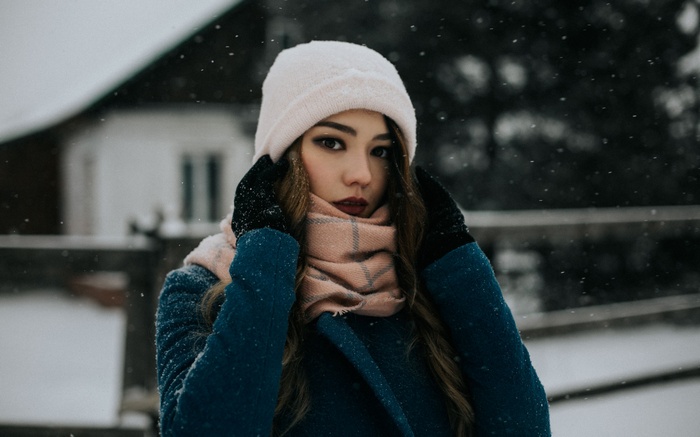Woman in blue coat and pink scarf in snow