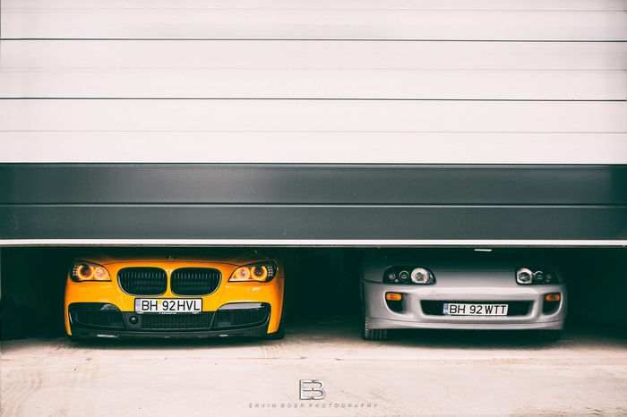 BMW 7 Series and Toyota Supra MK4 in garage
