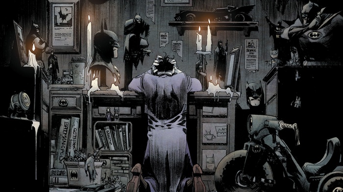 Joker sitting at a desk with Batman memorabilia