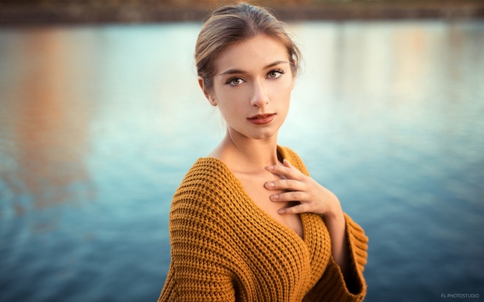 Woman in yellow sweater by the water