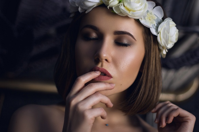 Woman with flower crown and finger on lips