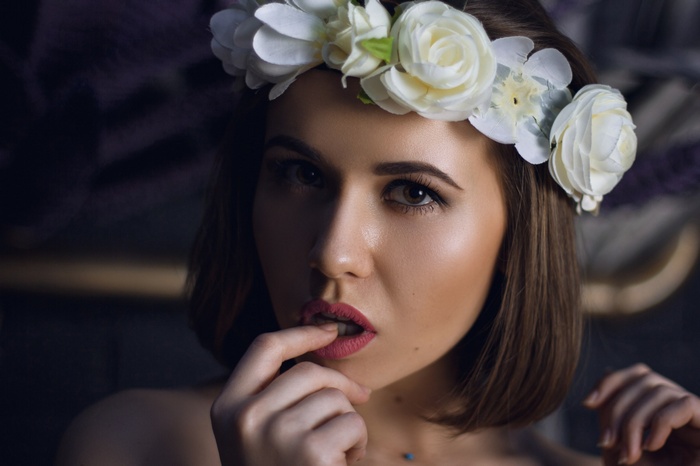 Woman with flower crown and finger on lips