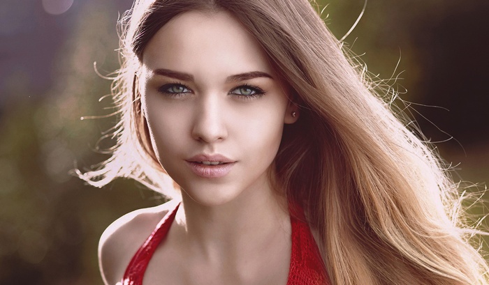 Woman with long blonde hair and blue eyes in red top