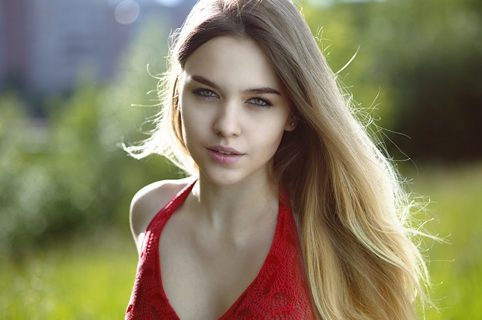 Woman with long blonde hair in red clothing outdoors