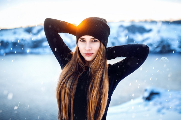 Woman in black hat and sweater in snow